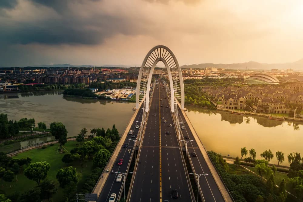 Bridge at sunset leading to a city skyline